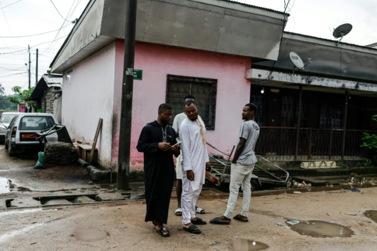 Des amis et des proches se tiennent près du domicile de Mohamed Pouamou, un chauffeur camerounais de 22 ans victime collatérale d'une manifestation ayant suivi la réélection contestée de Paul Biya, le 31 octobre 2025 à Douala ( AFP / - )