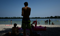Des habitants cherchent la fraicheur à l'ombre sur la rive du lac de Bordeaux, le 10 août 2025, en pleine vague de chaleur ( AFP / Philippe LOPEZ )