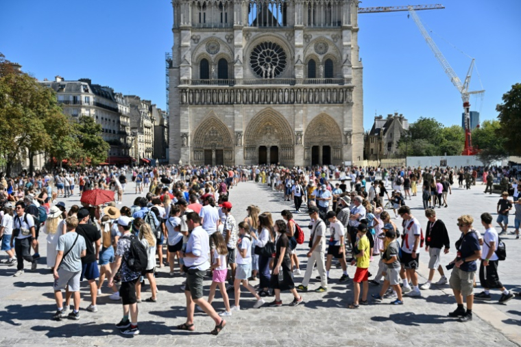 Des touristes devant la cathédrale Notre-Dame de Paris, le 17 août 2025 ( AFP / Martin LELIEVRE )