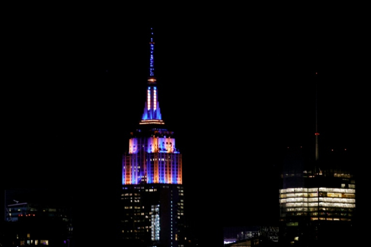 L'Empire State Building aux couleurs des New York Knicks, titrés en NBA, le 13 juin 2026 ( AFP / Leonardo MUNOZ )
