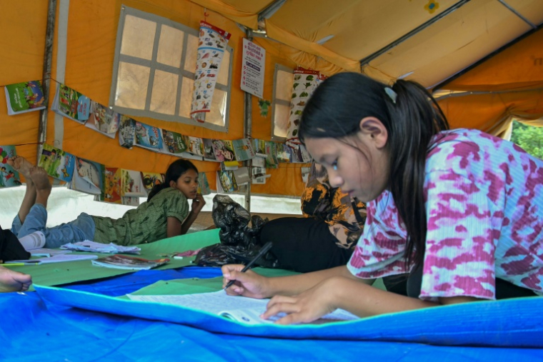 Des enfants, séparés de leurs parents par les crues, étudient dans un centre d’apprentissage géré par l’organisation caritative Save the Children, dans le district de Nuwakot, au Népal, le 11 septembre 2026 ( AFP / Prakash MATHEMA )