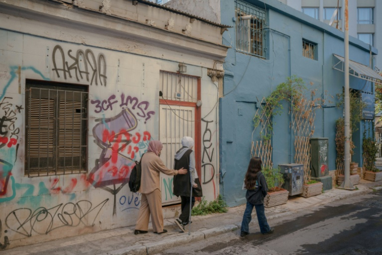 Les réfugiées palestiniennes Raghad al-Fara, au centre et Argwan al-Fara, à droite, et leur mère Shadia al-Fara, à gauche, à Athènes le 24 novembre 2025 ( AFP / Angelos TZORTZINIS )