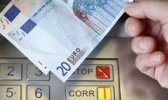 Billets de 20 et 50 euros devant un distributeur automatique de billets