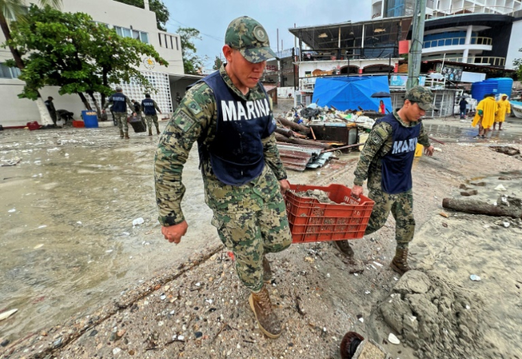 Des membres de la marine nationale participent au nettoyage après le passage de l'ouragan Erick à Puerto Escondido, dans l'Etat d'Oaxaca, au Mexique, le 19 juin 2025 ( AFP / CARLO ECHEGOYEN )