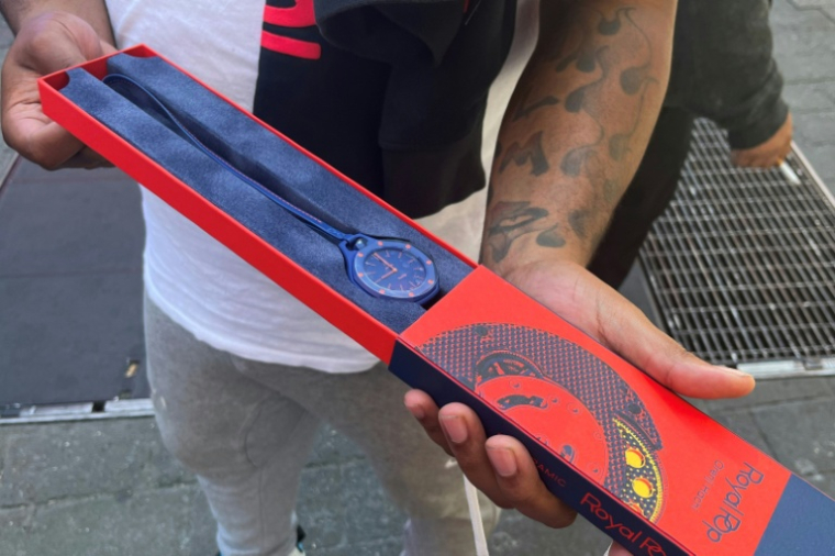 Un client montre sa montre Audemars Piguet Swatch Royal Pop qu'il vient d'acheter devant une boutique Swatch à Time Square, le 16 mai 2026 à New York  ( AFP / Raphaëlle PELTIER )