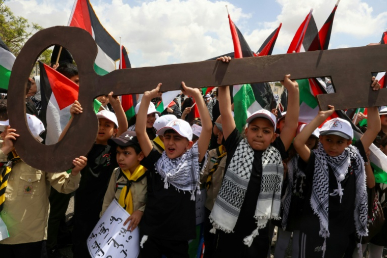 Des enfants palestiniens brandissent une clé symbolisant celle des maisons abandonnées par les Palestiniens en 1948 lors d'un rassemblement pour commémorer le 77e anniversaire de la « Nakba » à Ramallah en Cisjordanie occupée le 14 mai 2025 ( AFP / Zain JAAFAR )