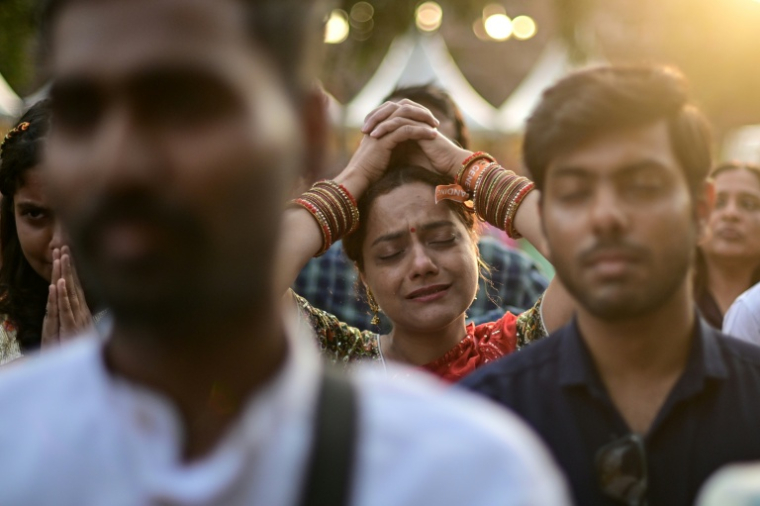 Des fêtards se laissant emporter par des chants spirituels hindous appelés "bhajans" au fort de Purana Qila à New Delhi, le 1er mars 2026 ( AFP / Manan VATSYAYANA )