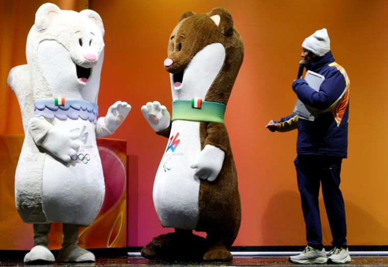 Les hermines Milo (d) et Tina, mascottes des Jeux olympiques de Milan-Cortina, à Cortina d’Ampezzo avant le dernier relais de la flamme olympique dans la ville, le 26 janvier 2026 ( AFP / Odd ANDERSEN )