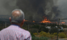 Un homme observe des flammes d'un incendie de forêt s'approcher des maisons, près de Bedar, dans le district de Los Gallardos, dans la province d'Almería, le 10 juillet 2026 en Espagne ( AFP / JOSE JORDAN )