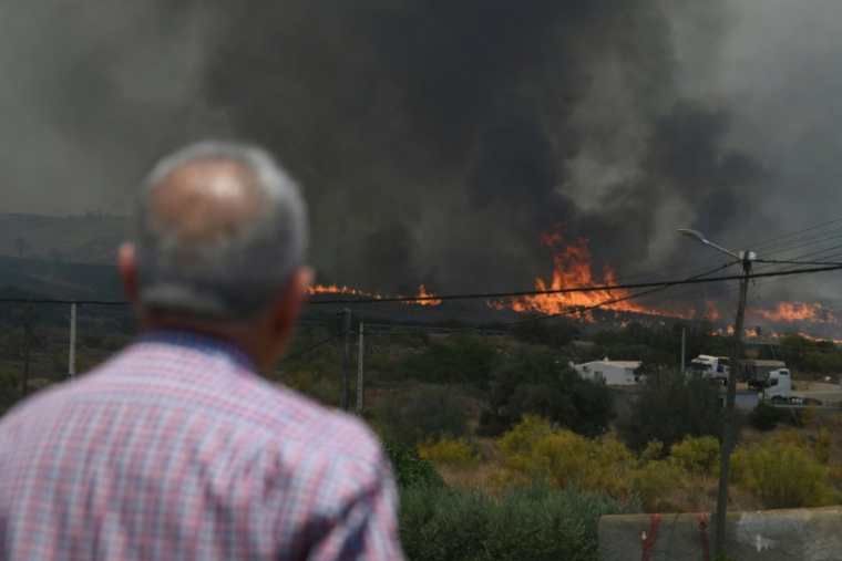 Un homme observe des flammes d'un incendie de forêt s'approcher des maisons, près de Bedar, dans le district de Los Gallardos, dans la province d'Almería, le 10 juillet 2026 en Espagne ( AFP / JOSE JORDAN )