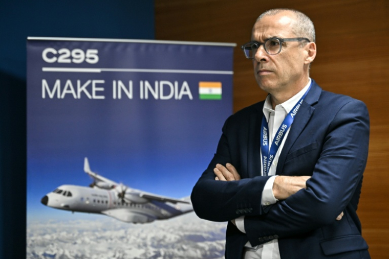 Jocelyn Gaudin, vice-président et directeure de l'ingénierie chez Airbus Inde et Asie du Sud, à côté d'une affiche publicitaire  au centre numérique de Bengaluru, le 16 février 2026 ( AFP / Idrees MOHAMMED )
