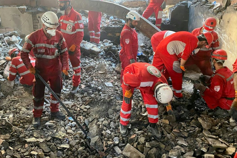 Des secouristes iraniens fouillent les décombres après une frappe israélienne à Téhéran. Photo distribuée par le Croissant rouge iranien le 17 juin 2025 ( Iranian Red Crescent / - )