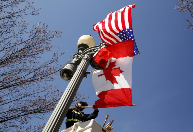 Un drapeau canadien aux côtés d'un drapeau américain sur un lampadaire de Pennsylvania Avenue, devant la Maison Blanche à Washington