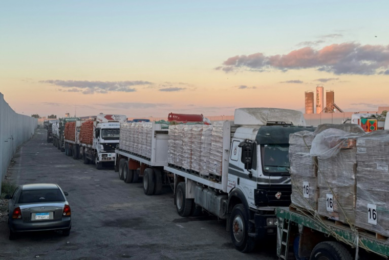 Des camions chargés d’aide humanitaire, du côté égyptien du passage de Rafah, attendent d'entrer dans la bande de Gaza le 15 octobre 2025 ( AFP / STR )