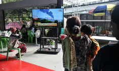 Des personnes déplacées par les combats à la frontière aavec le Cambodge regardent les informations à la télévision dans un centre pour évacués dans la province thaïlandaise de Surin, le 11 décembre 2025 ( AFP / Lillian SUWANRUMPHA )