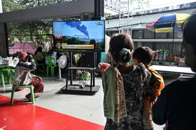 Des personnes déplacées par les combats à la frontière aavec le Cambodge regardent les informations à la télévision dans un centre pour évacués dans la province thaïlandaise de Surin, le 11 décembre 2025 ( AFP / Lillian SUWANRUMPHA )