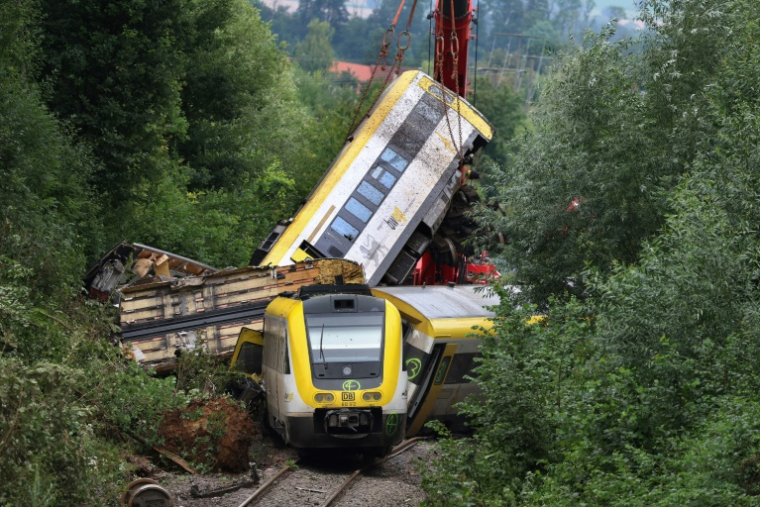 Une grue soulève le wagon endommagé d'un train, près de Riedlingen, dans le sud-ouest de l'Allemagne, le 28 juillet 2025, après son déraillement la veille ( AFP / Karl-Josef Hildenbrand )
