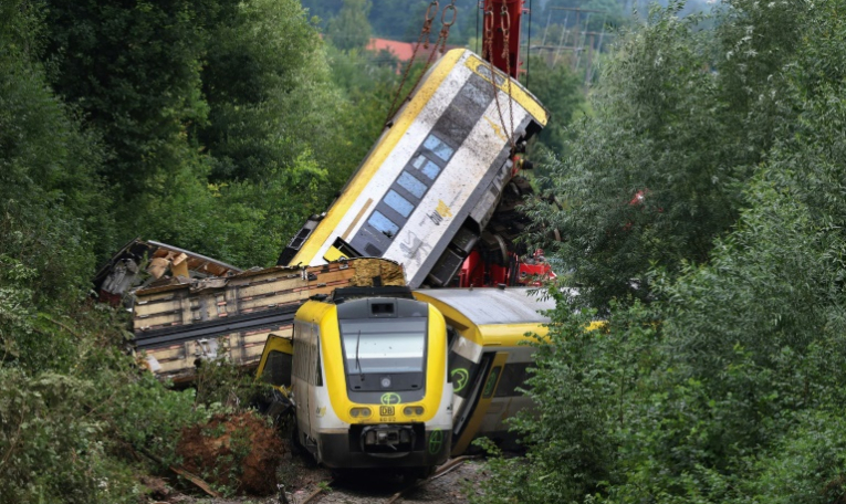Une grue soulève le wagon endommagé d'un train, près de Riedlingen, dans le sud-ouest de l'Allemagne, le 28 juillet 2025, après son déraillement la veille ( AFP / Karl-Josef Hildenbrand )