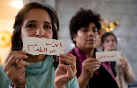 La journaliste égyptienne Mona Selim tient une pancarte sur laquelle on peut lire "Grève de la faim" alors qu'elle participe à un sit-in à l'intérieur du Syndicat du journalisme pour demander la libération du militant égypto-britannique Alaa Abd el-Fattah, au Caire