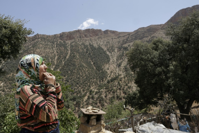 Une habitante du hameau d'Imzerri utilise la pratique ancienne du langage sifflé, permettant de communiquer à travers de vastes distances, le 19 août 2025 dans les montagnes de l'Atlas, au Maroc ( AFP / Abdel Majid BZIOUAT )