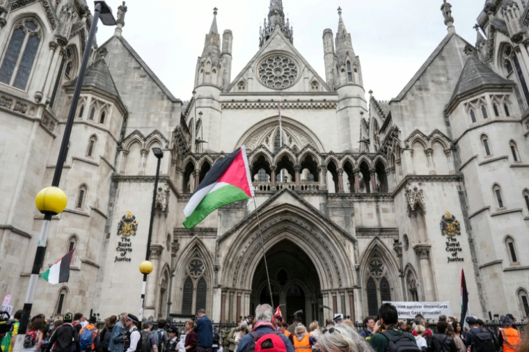 Des manifestants tiennent un drapeau palestinien devant la Cour royale de justice, alors que la Haute Cour rend son verdict sur l'interdiction du groupe Palestine Action, le 15 juin 2026 à Londres ( AFP / CARLOS JASSO )