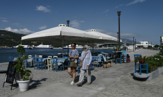 Des touristes venus de Turquie se promènent dans le village de Vathy, sur l’île de Samos, le 25 juillet 2026 ( AFP / Sakis Mitrolidis )