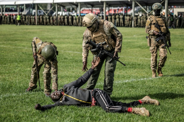Des membres des forces de l'ordre du Kenya assistent un partisan de l'opposant Raila Odinga, dans le stade où son corps est exposé, à Kisumu, le 18 octobre 2025 ( AFP / Luis TATO )