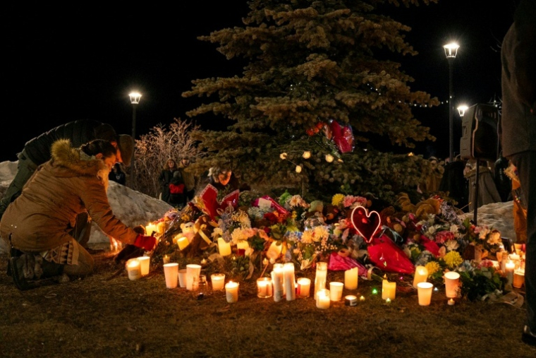 Des fleurs et des bougies déposées lors d'une veillée en hommage aux victimes de la tuerie à Tumbler Ridge, le 11 février 2026 au Canada ( AFP / Paige Taylor White )