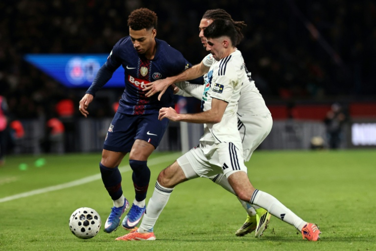 Le joueur du Paris SG Désiré Doué, balle au pied, au duel avec celui du Paris FC Thibault De Smet (à droite), à l'occasion du 16e de finale de Coupe de France remporté par le PFC, le 12 janvier 2026, au Parc des Princes ( AFP / Anne-Christine POUJOULAT )