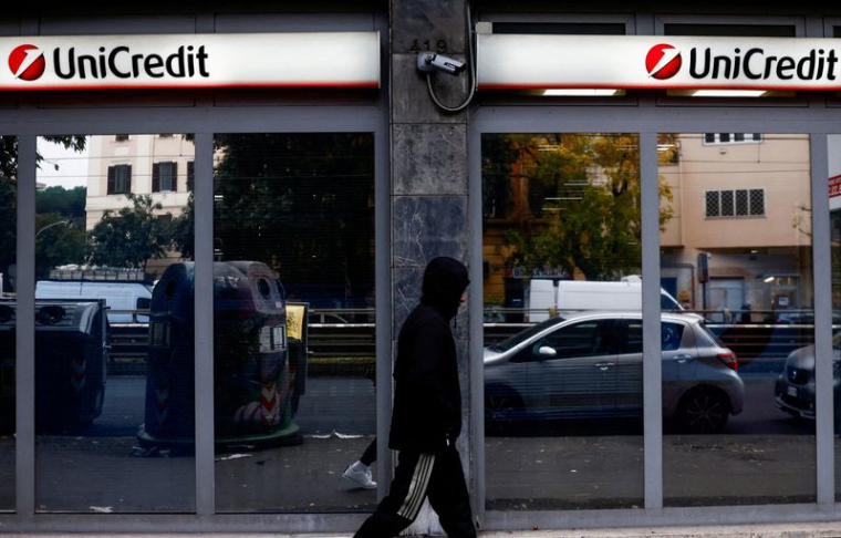 Une personne passe devant une agence de la banque UniCredit à Rome