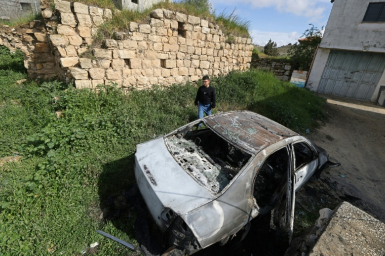 Un Palestinien à proximité d'un véhicule calciné après une attaque attribuée à des colons israéliens à Jalud, près de Naplouse, en Cisjordanie occupée, le 22 mars 2026 ( AFP / JAAFAR ASHTIYEH )