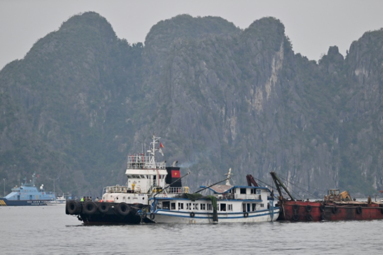 Opérations de remorquage du bateau de tourisme qui a fait naufrage dans la province vietnamienne côtière de Quang Ninh, le long de la Baie d'Halong, le 20 juillet 2025 ( AFP / Nhac NGUYEN )