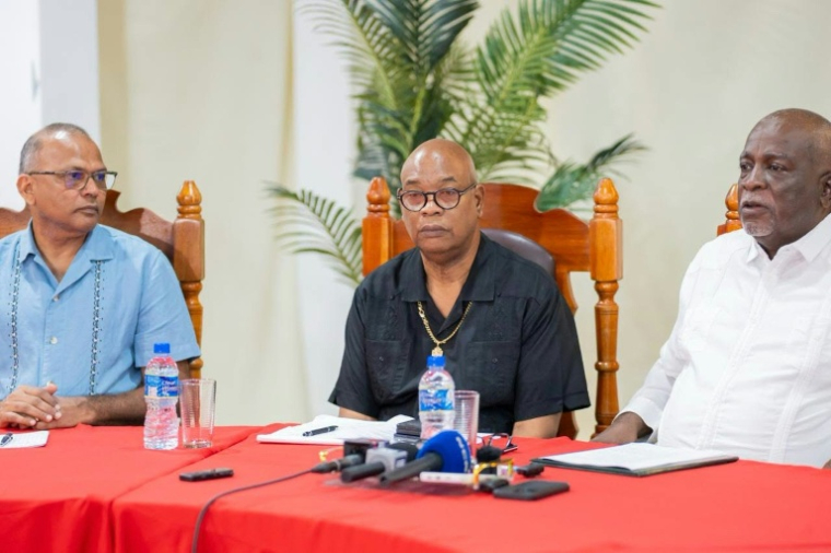 Photo diffusée par NCN Guyana montrant (g-d) le ministre de la Santé du Guyana, le Dr Frank Anthony, le ministre des Travaux publics du Guyana, Juan Edhill, et le Premier ministre du Guyana, Mark Phillips, lors d'une conférence de presse à Georgetown, le 19 juillet 2026, après le chavirage d'un ferry au Guyana ( NCN Guyana / Handout )
