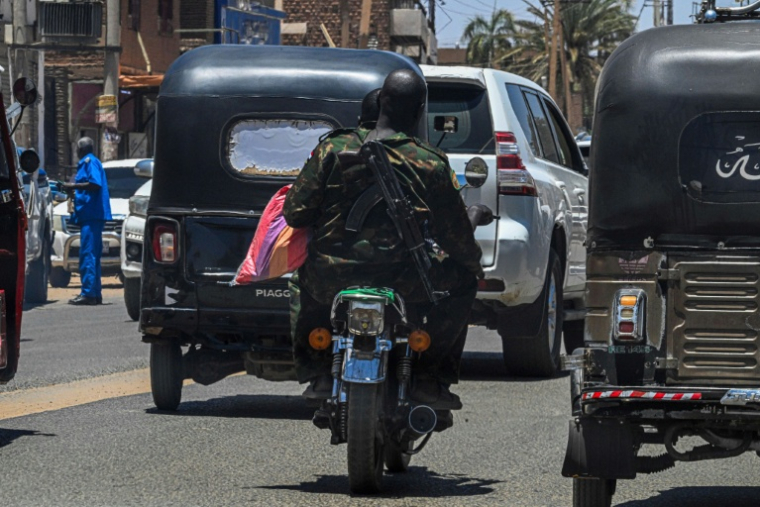 Un soldat de l'armée soudanaise porte une Kalachnikov en bandoulière, le 16 avril 2026 dans les rues de Khartoum ( AFP / Khaled DESOUKI )