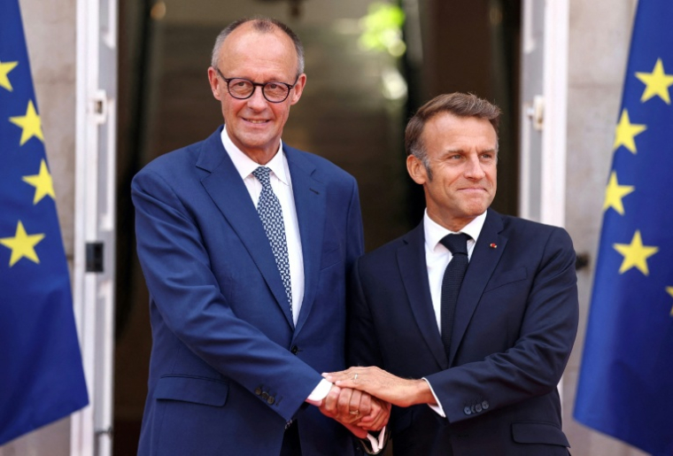 Le président français Emmanuel Macron (d) et le chancelier allemand Friedrich Merz se serrent la main avant une réunion à Toulon, dans le sud-est de la France, le 29 août 2025 ( POOL / Manon Cruz )