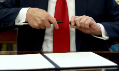 Le président des États-Unis Donald Trump signe un document dans le Bureau ovale à la Maison Blanche à Washington