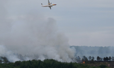 Un bombardier d'eau Dash 8-Q400 MR de la Sécurité civile largue de l'eau au-dessus de la forêt de Brocéliande après qu'un incendie s'est déclaré, le 17 juillet 2025 à Tréhorenteuc, dans le Morbihan ( AFP / Damien MEYER )
