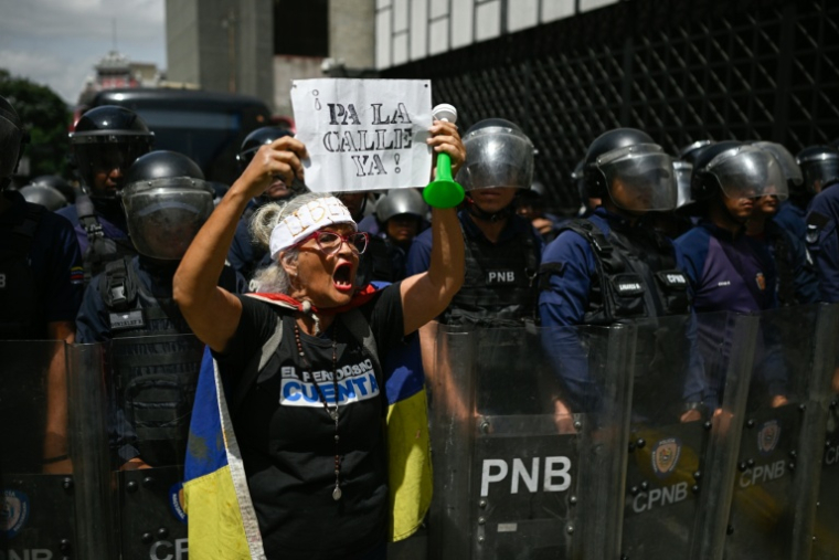 "Dans la rue maintenant!" sur une pancarte brandie par une manifestante le 29 mai 2026 à Caracas ( AFP / Federico PARRA )