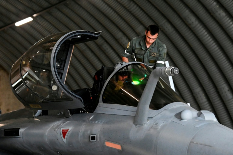 Un mécanicien aide un pilote de Rafale à s'équiper dans un abri protégé de la base aérienne d'Orange ( AFP / Sylvain THOMAS )