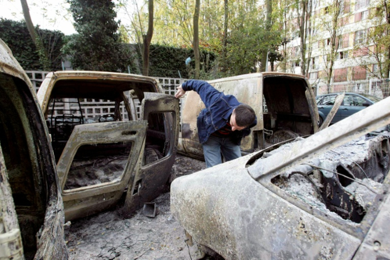 Des véhicules carbonisés de la Poste à Clichy-sous-Bois, le 28 octobre 2005, en Seine-Saint-Denis après des d'émeutes impliquant des dizaines de jeunes qui s'en sont pris dans la nuit aux pompiers, aux policiers et à des bâtiments publics, après la mort accidentelle par électrocution de deux mineurs fuyant la police dans un transformateur EDF de la ville ( AFP / Thomas COEX )