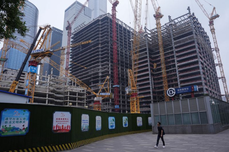 Une personne passe devant un chantier de construction dans le quartier central des affaires (CBD) de Pékin.