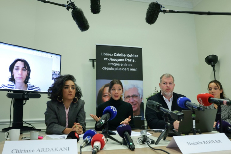 Anne-Laure Paris apparait sur un écran à gauche pendant une conférence de presse à laquelle participent, de gauche à droite, l'avocate Chirinne Ardakani, Noémie Kohler, l'avocat Martin Pradel et l'avocate Emma Villard à Paris le 16 octobre 2025 ( AFP / Thomas SAMSON )