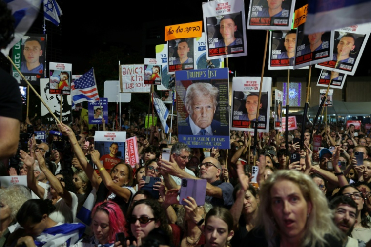 Des personnes brandissent des drapeaux israéliens et américains lors d'un rassemblement sur la place des Otages à Tel-Aviv, le 11 octobre 2025 ( AFP / Jack GUEZ )