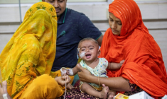 Une femme réconforte un enfant atteint de la rougeole à l'hôpital Shishu à Dacca le 6 mai 2026 ( AFP / Salahuddin AHMED )