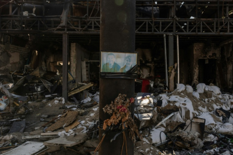 Un portrait en mémoire de personnes tuées est accroché à une station-service brûlée, près de la ville d’Izioum, région de Kharkiv dans l'est de l'Ukraine, le 29 juillet 2026 ( AFP / Roman PILIPEY )
