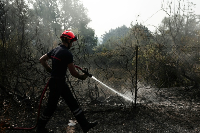 Un pompier essaie d'éteindre un incendie le 22 juillet 2026 à Cotignac ( AFP / Thibaud MORITZ )