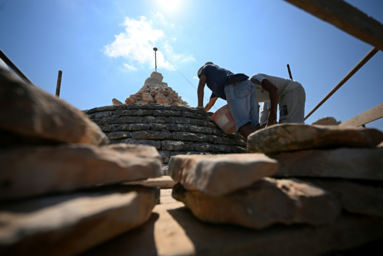 Des restaurateurs de trulli à Ostuni, en Italie, le 24 juin 2026 ( AFP / Tiziana FABI )