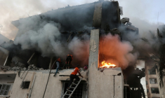 Des secouristes palestiniens opèrent dans un immeuble en feu après une frappe israélienne à Gaza-ville, le 22 novembre 2025 ( AFP / Omar AL-QATTAA )