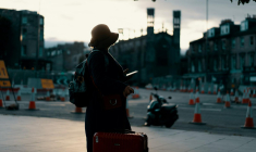 une touriste avec une valise (Crédits: Unsplash - Ross Sneddon)