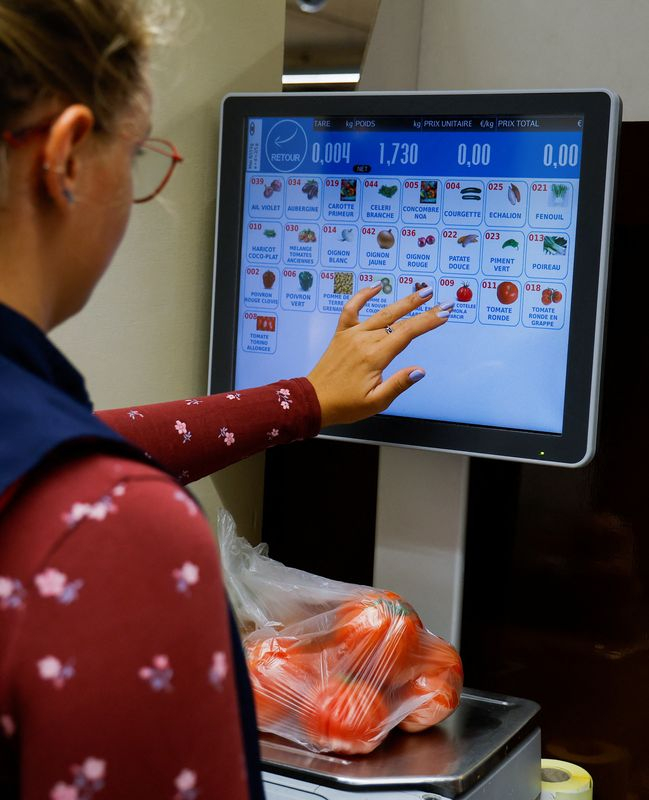 Un employé pèse des légumes dans un supermarché de Nice